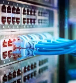 Colour-coded Cat-6 network cabling patched into a switch — structured data cabling by ACS Integration